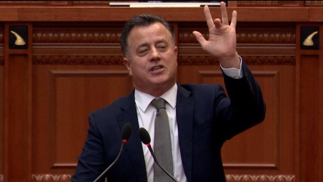 Flamur Noka sticks out his middle finger during the parliamentary session