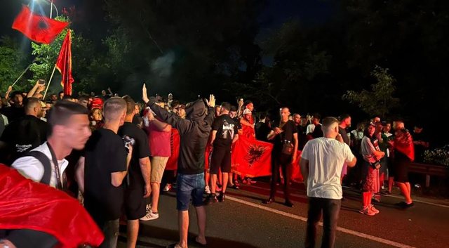 "Who is the person with the hat and megaphone leading the crowd in