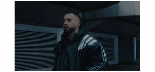 The moment when Gjesti enters the record company's offices armed