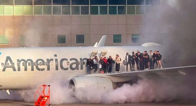 American Airlines plane catches fire. Passengers jump out of the wings